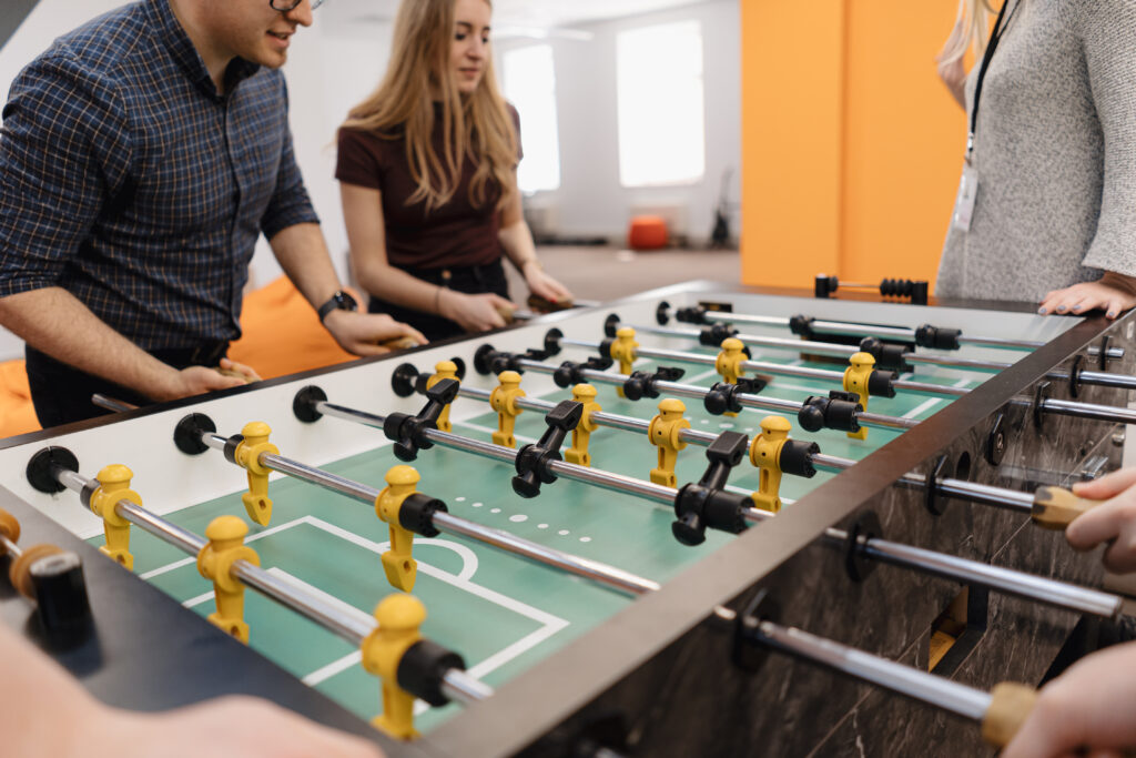 young office workers playing table soccer